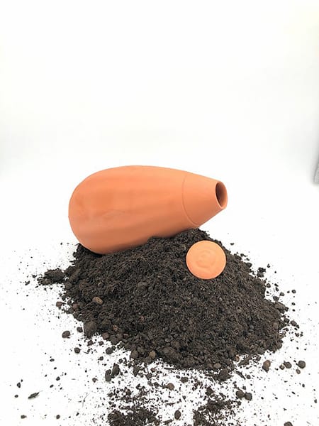 Une olla XL apposée sur de la terre, bouchon ouvert