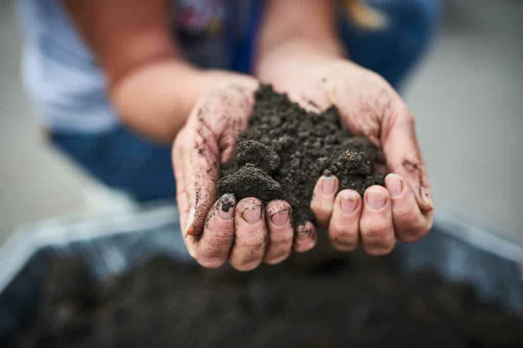 Hands dirty with clay, soil background